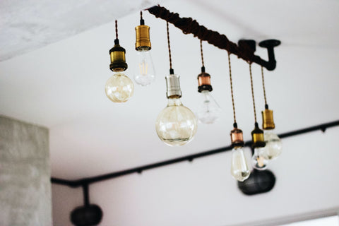 different-shaped lightbulbs hang in the ceiling of a white-colored room