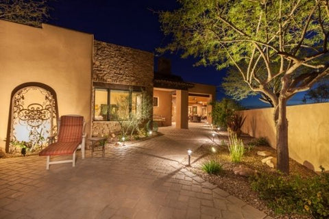 concrete house with a big pathway lit by several landscape lights at night