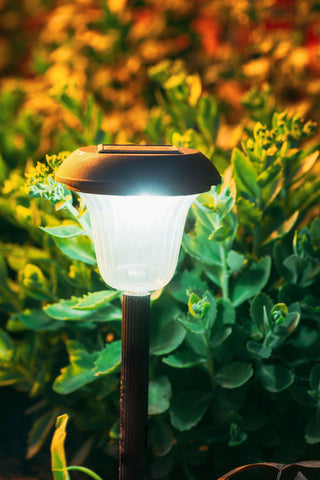 decorative garden light erected in a flower bed