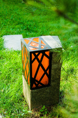 orange outdoor light placed in a grassy ground