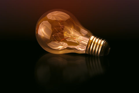 a light bulb with a reflection and a dark background