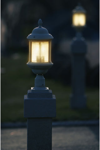 two lit lampposts in the driveway