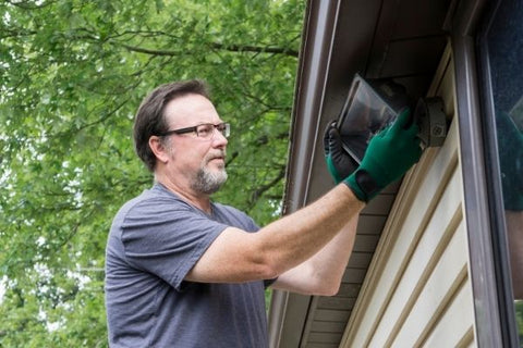 an electrician installing light outside the house