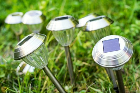several solar garden lights erected in a grassy land