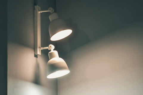 two lit up lampshades in a white wall