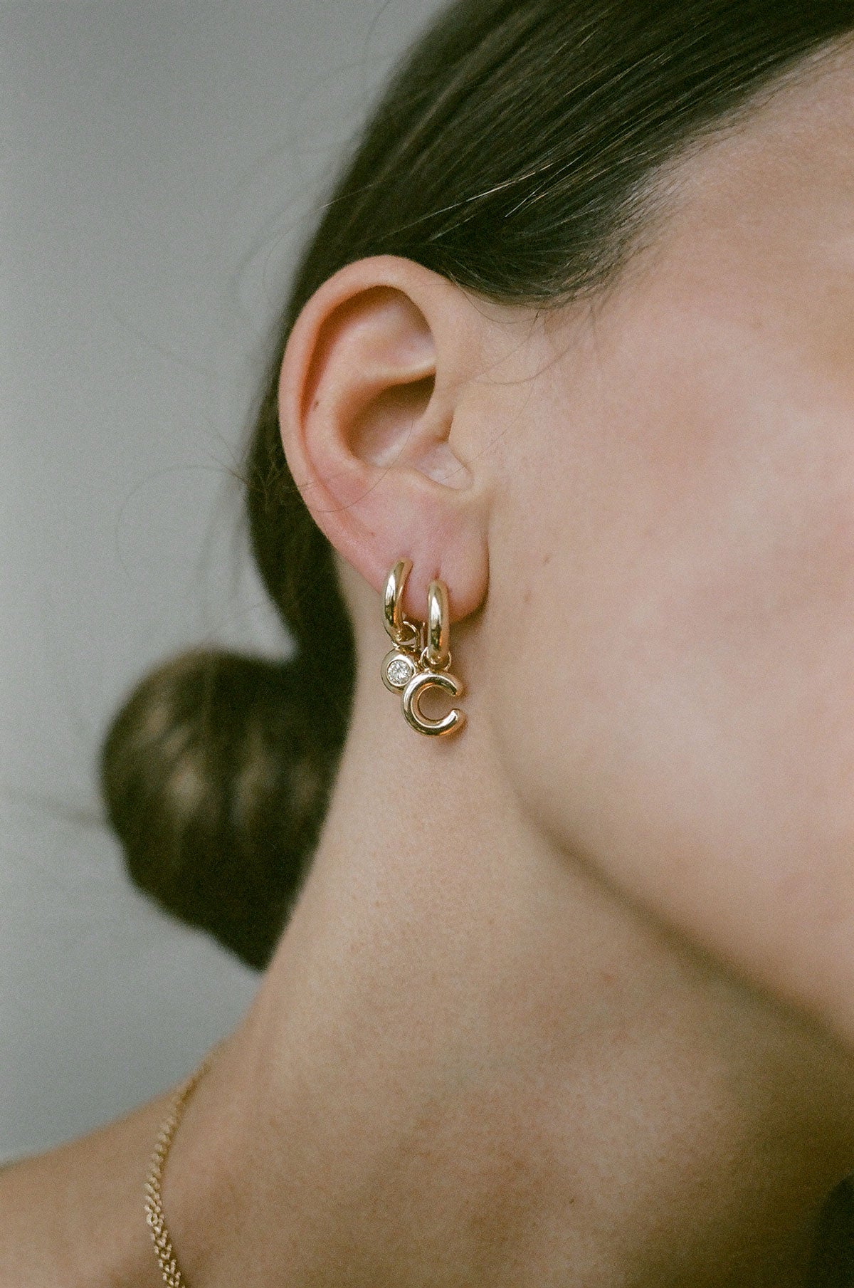 Model wearing J. Hannah Identity Charm Hoop earrings 14k gold