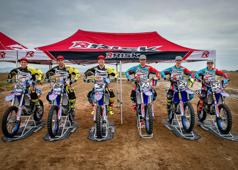 RISK Racing Europe Team Pics. Entire European team sitting on their yamaha dirt bikes on A.T.S. Stands & Factory Pit Mats, in front of a 10x20 risk racing canopy. All riders are wearing risk racing gear.