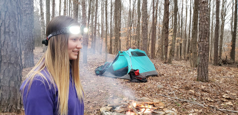 Camper wearing an stkr headlamp pro while they are out on a camping adventure in the woods.