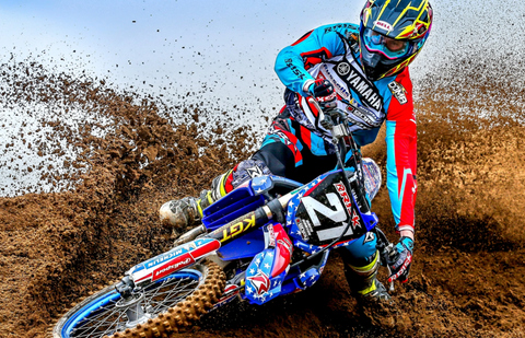 Motocross rider hitting a berm applying throttle. This motocross rider uses our Fusion 2.0 Grips.