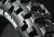 Súper Primer plano de un nuevo neumático 'The Tough One' Plews Tire Enduro en un entorno de estudio negro. Disparo detallado de las huellas y letras de la pared lateral.