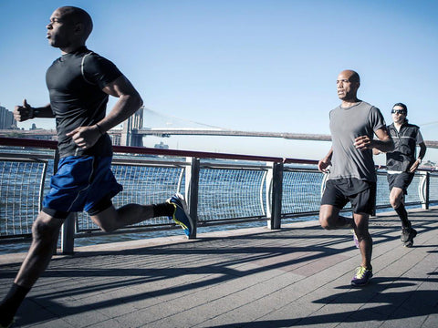 Group of runners jogging on a bath near a body of water. The runners are training both their  cardiovascular endurance, as well as their muscular endurance by jogging