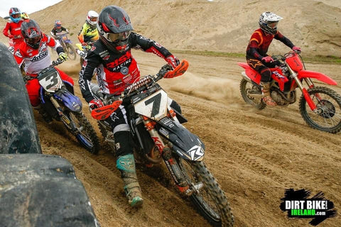 Risk racing athlete racing motocross. the rider is getting the leading the field into the first corner after the gate drop. The track is a sandy and loose with deep ruts in from the racer. The rider is wearing risk racing ventilate v2 motocross jersey, pants, and gloves.