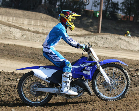 motocross rider and dirt bike absorbing an impact, the suspension compresses to cushion the impact.