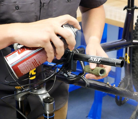 Spraying hairspray on the handlebar so that the grip slide on easily. When the hairspray evaporates the grip should be adhered to the bar.