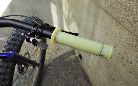 Slide on mountain bike grips installed on a bike. Wire has been included in the installation process on both ends of the grip to prevent the grips from sliding off.