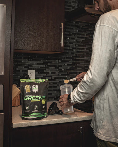 Motocross rider mixing iRide Supplements Greens Powder into a shaker bottle in the morning, to keep his digestive system, and immune system healthy.