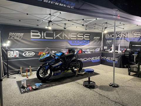 rISK Racing/STKR Work lights lighting up the pit area at a road racing america event.