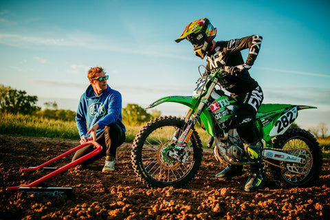 Motocross racer practicing their starts with their coach. The rider is using a RISK Racing Holeshot practice gate to perfect their starts.