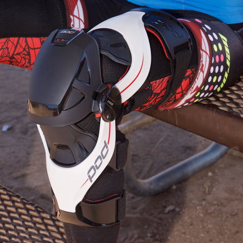 Motocross rider gearing up for a ride putting on their knee braces to protect their knee externally and internally.