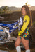 December's Risk Racing Moto Model Kelly Perez posing in various bikinis and Risk Racing Jerseys next to a dirt bike that's sitting on a Risk Racing ATS stand - Pose #23