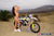 October's Risk Racing Moto Model Jessica Victorino posing in various bikinis and Risk Racing Jerseys next to a dirt bike that's sitting on a Risk Racing RR1-Ride-On stand - Pose #24