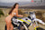 La modelo de moto de Risk Racing de octubre, Jessica Victorino, posa con varios bikinis y camisetas de Risk Racing junto a una moto de cross que está sentada en un soporte de Risk Racing RR1-Ride-On - Pose #27