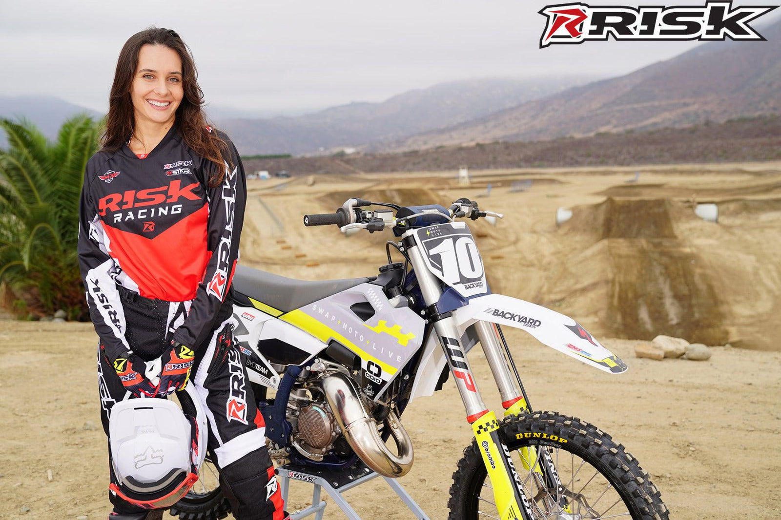October's Risk Racing Moto Model Jessica Victorino posing in various bikinis and Risk Racing Jerseys next to a dirt bike that's sitting on a Risk Racing RR1-Ride-On stand - Pose #33