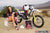 La modelo de moto de Risk Racing de octubre, Jessica Victorino, posa con varios bikinis y camisetas de Risk Racing junto a una moto de cross que está sentada en un soporte de Risk Racing RR1-Ride-On - Pose #35