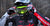 Primer plano de un piloto de motocross masculino con un casco negro y ajustando sus gafas Risk Racing JAC V3 con un sistema de caída automática Ripper