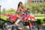 July's Risk Racing Moto Model Samantha Heady posing in various bikinis & Risk Racing Jerseys next to Alex Ray's Honda CR250R that's sidding on a Risk Racing ATS stand - Pose #32
