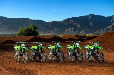 Kawasaki's factory 2022 team bikes lined up on a supercross track