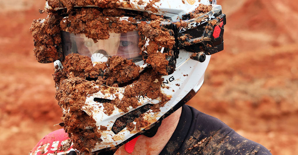 close up of a male motocross riders helmet completely covered in mud but vision clear via auto roll off by Risk Racing