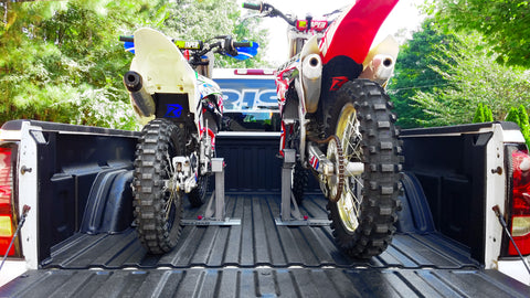 Two bikes mounted in the bed of a pick-up truck using risk racing's lock-n-load system. A full size bike version and mini bike version are sold by risk racing as pictured.
