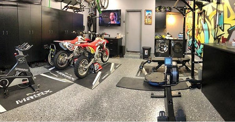 Dirt bikes in a fully equipped mancave set up with a work out are washer machines refrigerator and all the tool cabinets and gear storage anyone could need.
