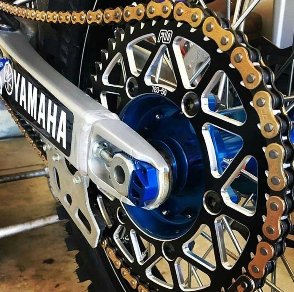 close up of a swing arm sproket and chain of a very clean dirt bike