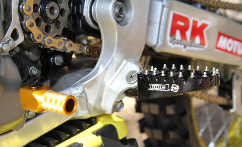 Gear shifter on dirt bike, located on the left side of the the motorcycle in front of the footpeg.