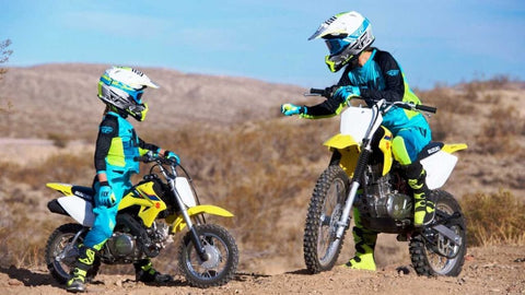 Parent instructing young rider how to operate the dirt bike.