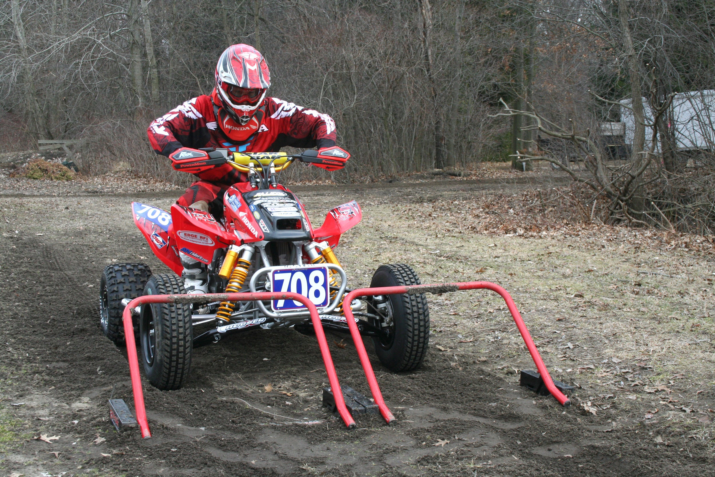 Quad rouge quatre roues alignés pour un départ de course à deux portes de course Holeshot Risk Racing