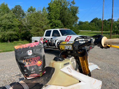 iRide Supplements Hydro Fuel sitting on the seat of a dirt bike seat at a motocross track