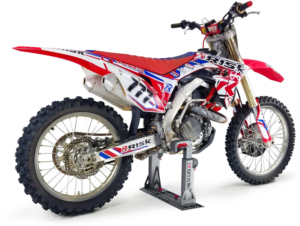 white studio pic of a motocross dirt bike secured into a lock n load pro transport system by Risk Racing