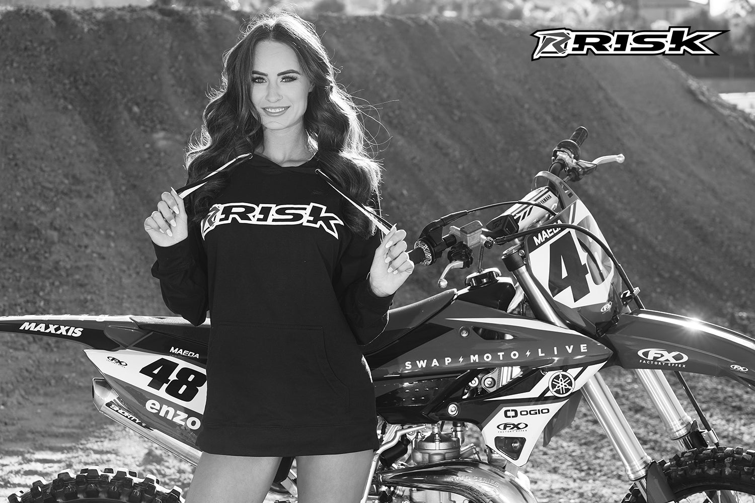 Moto Model Kylie Walton dans Risk Racing Hoodie à côté de dirtbike | Échangez Moto Live et Risk Racing