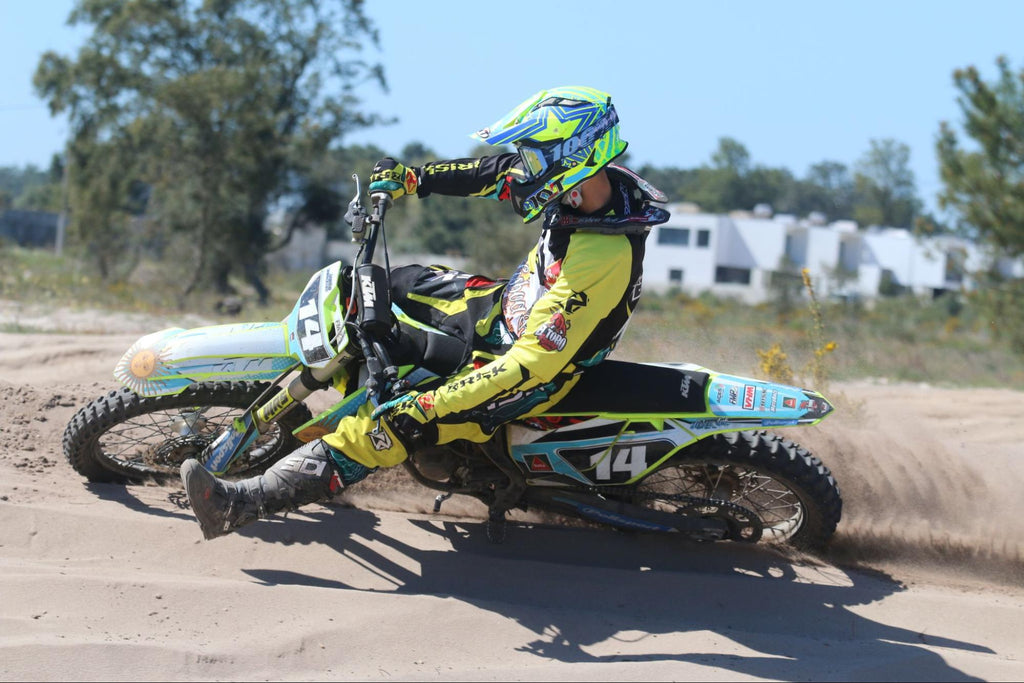 mx number 14 cornering in sand in full Risk Racing gear including jersey and pants