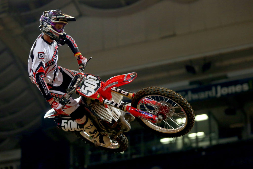 sx number 500 Risk Racing pro rider in full RR gear whipping through the air indoor supercross track