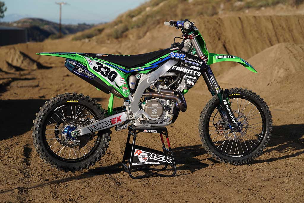 num 330 motocross bike sitting on an ATS adjustable top magnetic stand by Risk Racing outside in the dirt