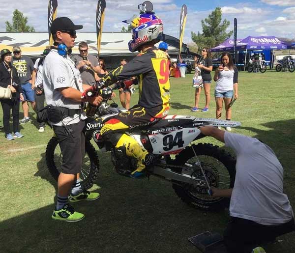 num 94 getting his suspension dialed in by two helpers in the mx pits