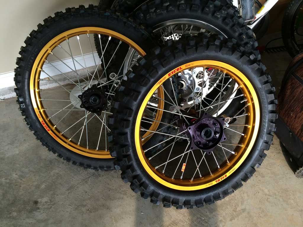 ein Haufen Schmutzrad Räder und Reifen in einer Garage