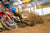 Motocross racer navigating through a rutted muddy area of a track. Pic is zoomed in on just the front tire and front forks of the motocross bike to highlight the Plews Tyres front tire.