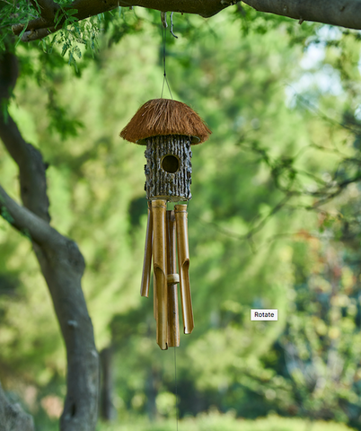 A classic wind chime in a leafy backdrop.