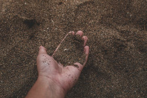 A man holds a handful of soil.