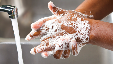 Soapy hands under water for All Portable Sinks blog